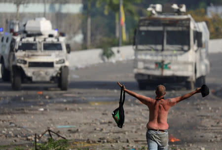 An opposition supporter walks towards military vehicles during clashes with security forces following a rally against the government of Venezuela's President Nicolas Maduro and to commemorate May Day in Caracas, Venezuela May 1, 2019. REUTERS/Manaure Quintero