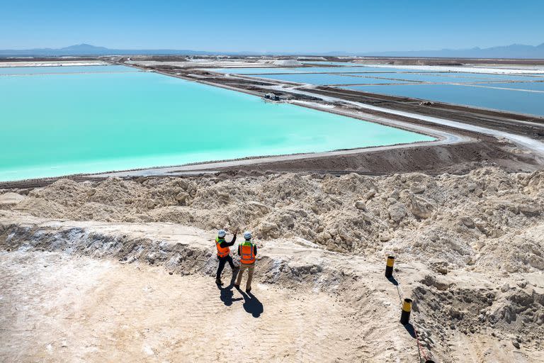 Chile extrae litio de las salinas del desierto de Atacama
SALAR DE ATACAMA, CHILE - 24 DE AGOSTO: En esta vista aérea, los visitantes se paran sobre un gran montículo de subproducto de sal de la producción de litio en una mina en el desierto de Atacama el 24 de agosto de 2022 en Salar de Atacama, Chile. Albemarle Corporation, con sede en Charlotte, Carolina del Norte, está expandiendo las operaciones mineras allí para satisfacer la creciente demanda mundial de carbonato de litio, un componente principal en la fabricación de baterías, cada vez más para vehículos eléctricos. En la Planta Salar, la salmuera natural se bombea desde debajo de vastas salinas a una serie de estanques de evaporación. Durante un proceso de 18 meses, el líquido se movió a través de 15 estanques y eventualmente cambió de azul oscuro a amarillo brillante con una concentración de litio del 6 por ciento. Luego se transporta en camiones a una planta química de Albemarle en Antofagasta, donde se procesa en polvo de carbonato de litio apto para baterías y se envía internacionalmente. El proceso de evaporación produce grandes cantidades de subproductos de sal, muchos de los cuales luego se reprocesan y venden. Chile es el segundo mayor productor mundial de litio, después de Australia