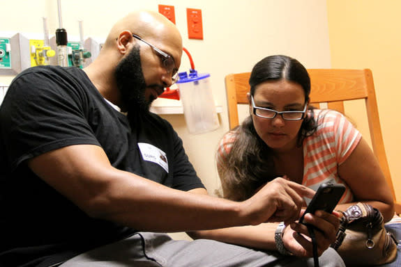 Calvin and Emily Barr look at an image of their son, Calvin, Jr., during a recent surgery at Arnold Palmer Hospital for Children in Orlando, Florida. The Barrs signed up to use the EASE app during their son`s surgery, allowing them to get updat