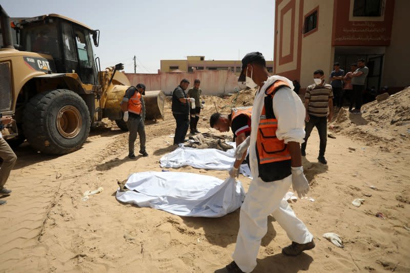 Civil Defense teams continue to remove the decomposed and dismembered bodies of Palestinians who lost their lives after Israeli attacks in Khan Yunis southern Gaza, on Wednesday.The United Nations has called for an “independent, effective and transparent investigation” into the discovery of mass graves at two Gaza hospitals that were besieged and raided by Israeli troops this year. Photo by Ismael Mohamad/UPI