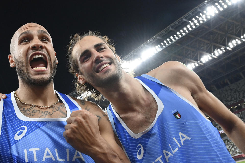 High jump gold medalist Gianmarco Tamberi, right, of Italy, celebrates with compatriot Lamont Marcell Jacobs, after he won the final of the men's 100-meters at the 2020 Summer Olympics, Sunday, Aug. 1, 2021, in Tokyo. (Alfredo Falcone/LaPresse via AP)