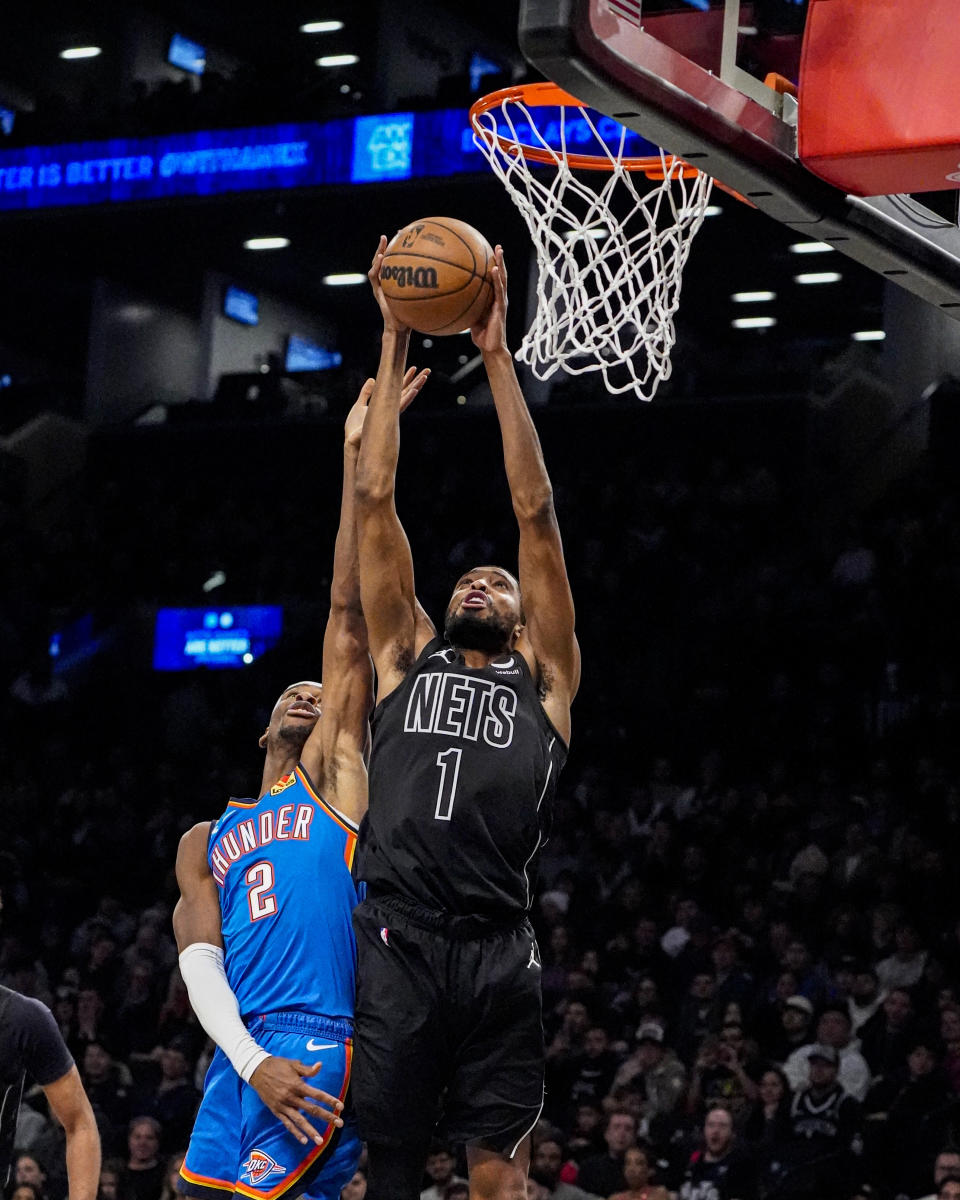 Brooklyn Nets forward Mikal Bridges (1) grabs a rebound over Oklahoma City Thunder guard Shai Gilgeous-Alexander (2) during the first half of an NBA basketball game in New York, Friday, Jan. 5, 2024. (AP Photo/Peter K. Afriyie)