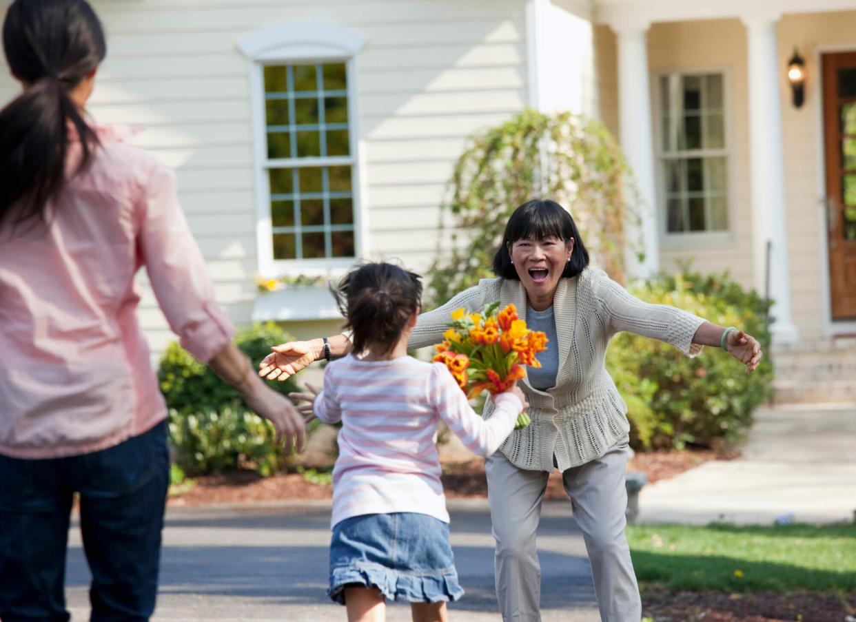 child running to grandmother with flowers
