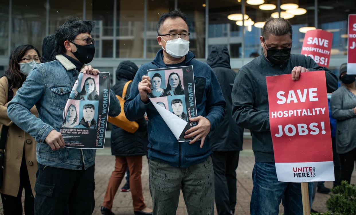 <span class="caption">Hilton Metrotown hotel employees hold signs and posters during a news conference outside the hotel in Burnaby, B.C., in February 2021. The employees' union urged prospective guests not to stay at the hotel as a job action after dozens of workers were laid off. </span> <span class="attribution"><span class="source">THE CANADIAN PRESS/Darryl Dyck</span></span>