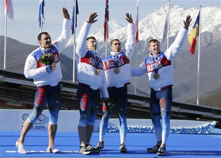 (L-R) Winners Russia's Alexey Voevoda, Dmitry Trunenkov,Alexey Negodaylo and pilot Alexander Zubkov, wave to spectators during a medal ceremony for the four-man bobsleigh event at the Sochi 2014 Winter Olympics, at the Sanki Sliding Center in Rosa Khutor February 23, 2014. REUTERS/Fabrizio Bensch