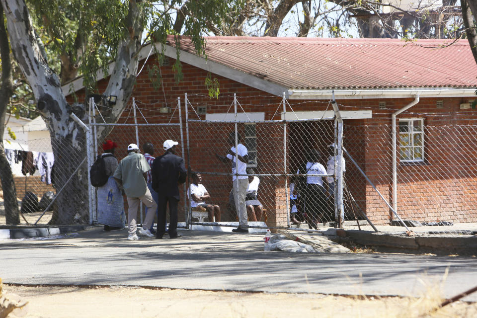Neighbours negotiate for entrance at the former President Robert Mugabe's rural home in Zvimba, about 100 kilometers north west of the capital Harare, Saturday, Sept. 28, 2019. According to a family spokesperson Mugabe is expected to be buried at the residence after weeks of drama mystery and contention over his burial place. (AP Photo/Tsvangirayi Mukwazhi)