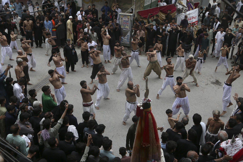 Shiite Muslims flagellate themselves with knifes on chains during a procession to mark Ashoura, in Peshawar, Pakistan, Tuesday, Aug. 9, 2022. Ashoura falls on the 10th day of Muharram, the first month of the Islamic calendar, when Shiites mark the death of Hussein, the grandson of the Prophet Muhammad, at the Battle of Karbala in present-day Iraq in the 7th century. (AP Photo/Muhammad Sajjad)