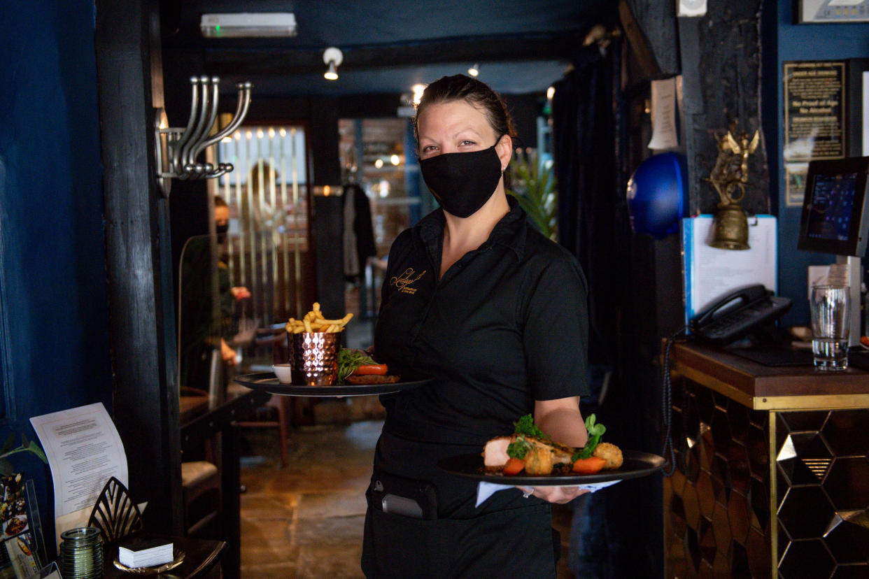 A waitress carries meals to a table during service at Loxleys Restaurant & Wine Bar in Stratford, Warwickshire, as indoor hospitality and entertainment venues reopen to the public following the further easing of lockdown restrictions in England. Picture date: Monday May 17, 2021. (Photo by Jacob King/PA Images via Getty Images)