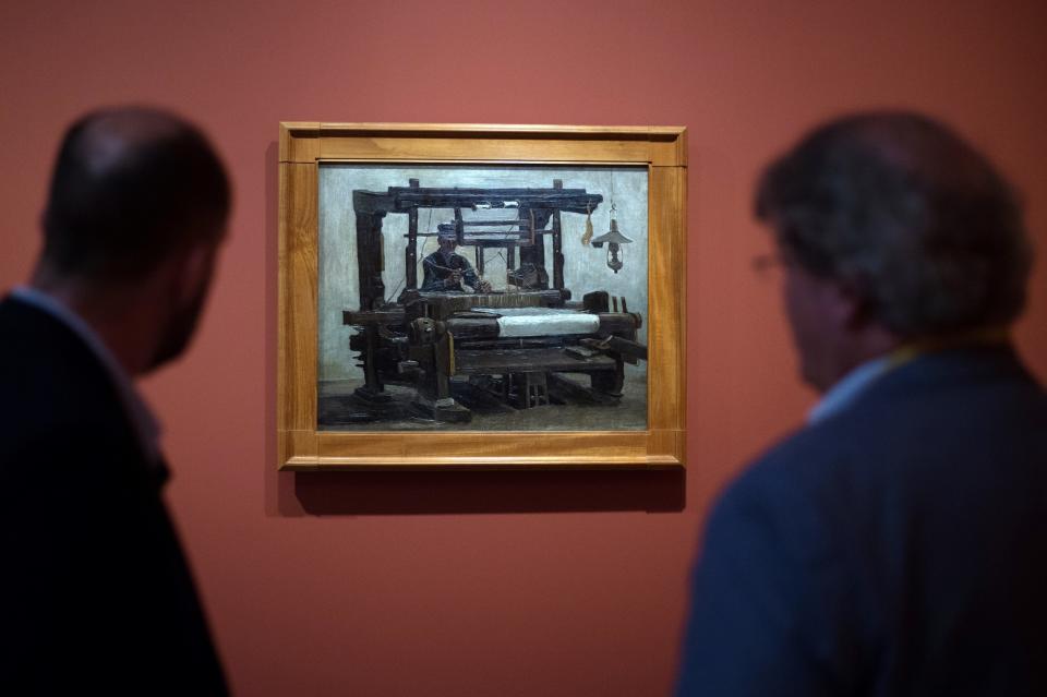 Men look at a painting by Vincent Van Gogh entitled 'Loom and Weaver' during the exhibition 'Van Gogh in Provence: Modernizing Tradition' at the Fondation Vincent Van Gogh Arles on May 13, 2016 in Arles, southern France.&nbsp;