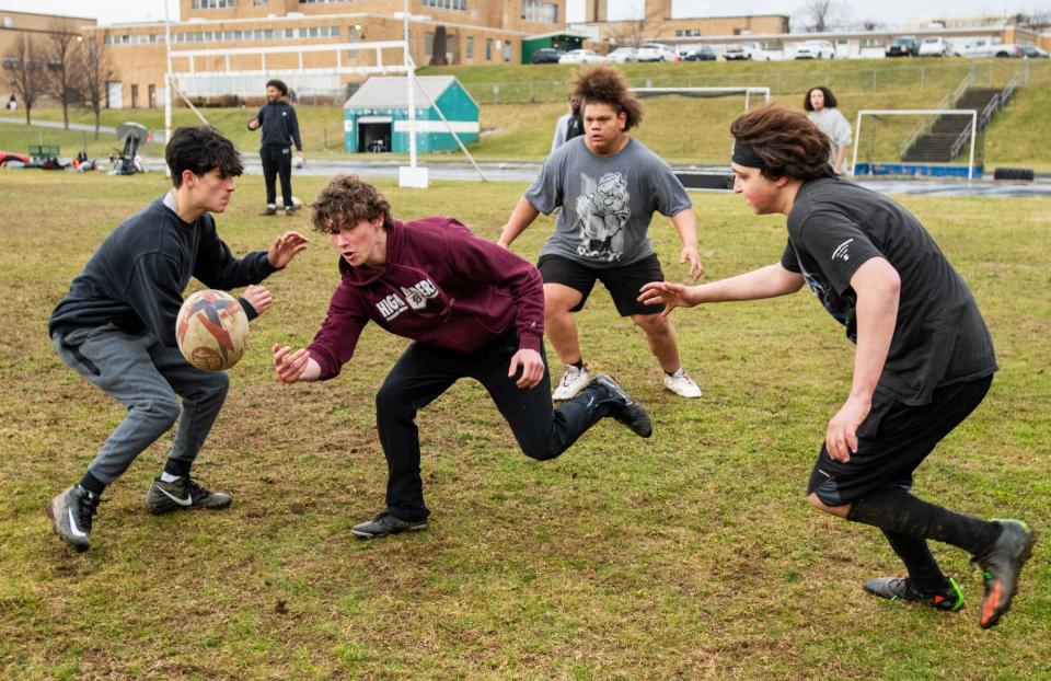 WORCESTER - Doherty High School junior Ben Gniadek, center, tosses the ball during rugby practice Thursday, March 21, 2024.