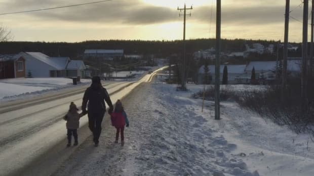 A foster mother in Roddickton walks with two Indigenous children from Labrador. Inuit kids in care are slowly returning home, according to Nunatsiavut. (Terry Roberts/CBC - image credit)