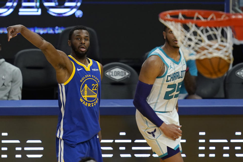 Golden State Warriors forward Andrew Wiggins (22) watches his three-point basket next to Charlotte Hornets forward P.J. Washington (25) during the second half of an NBA basketball game in San Francisco, Friday, Feb. 26, 2021. (AP Photo/Jeff Chiu)