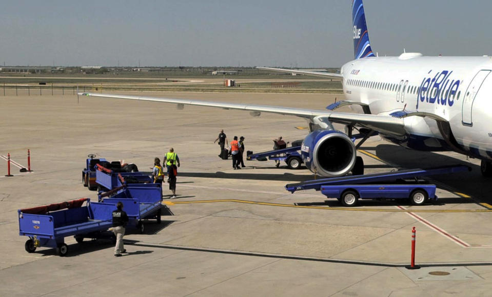 Officials remove baggage from JetBlue flight 191 and begin searching for explosives at Amarillo Rick Husband International Airport in Amarillo, Texas, Tuesday, March 27, 2012 after an unruly pilot caused the flight to make an emergency landing. A JetBlue flight bound for Las Vegas landed unexpectedly in Texas on Tuesday after the captain was taken ill, the airline said. A passenger said a man she and other passengers believed was the captain began yelling about a bomb and had to be restrained. (AP Photo/The Amarillo Globe News, Michael Schumacher)