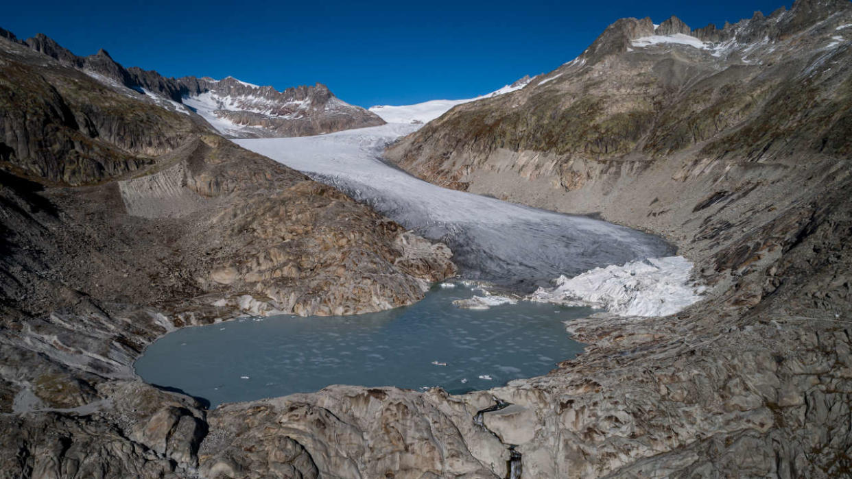 This aerial view taken on October 27, 2021 near Gletsch shows the Rhone Glacier and its glacial lake, formed by the melting of the glacier due to global warming. - Swiss glaciers lost 1% of their volume in 2021, despite heavy snow and a cool summer, due to climate change. 