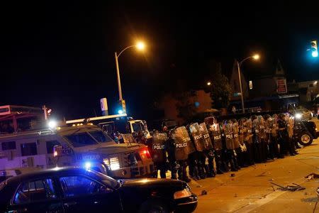 Police stand guard during disturbances following the police shooting of a man in Milwaukee, Wisconsin, U.S. August 14, 2016. REUTERS/Aaron P. Bernstein