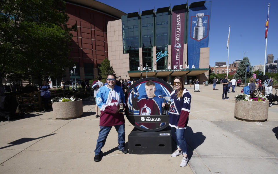 Michael Hedmark, left, and Baylee Weed celebrate after signing the mortgage for their first home on the way into Ball Arena to watch Game 1 of an NHL hockey Stanley Cup series between the Tampa Bay Lightning and Colorado Avalanche, Wednesday, June 15, 2022, in Denver. (AP Photo/David Zalubowski)