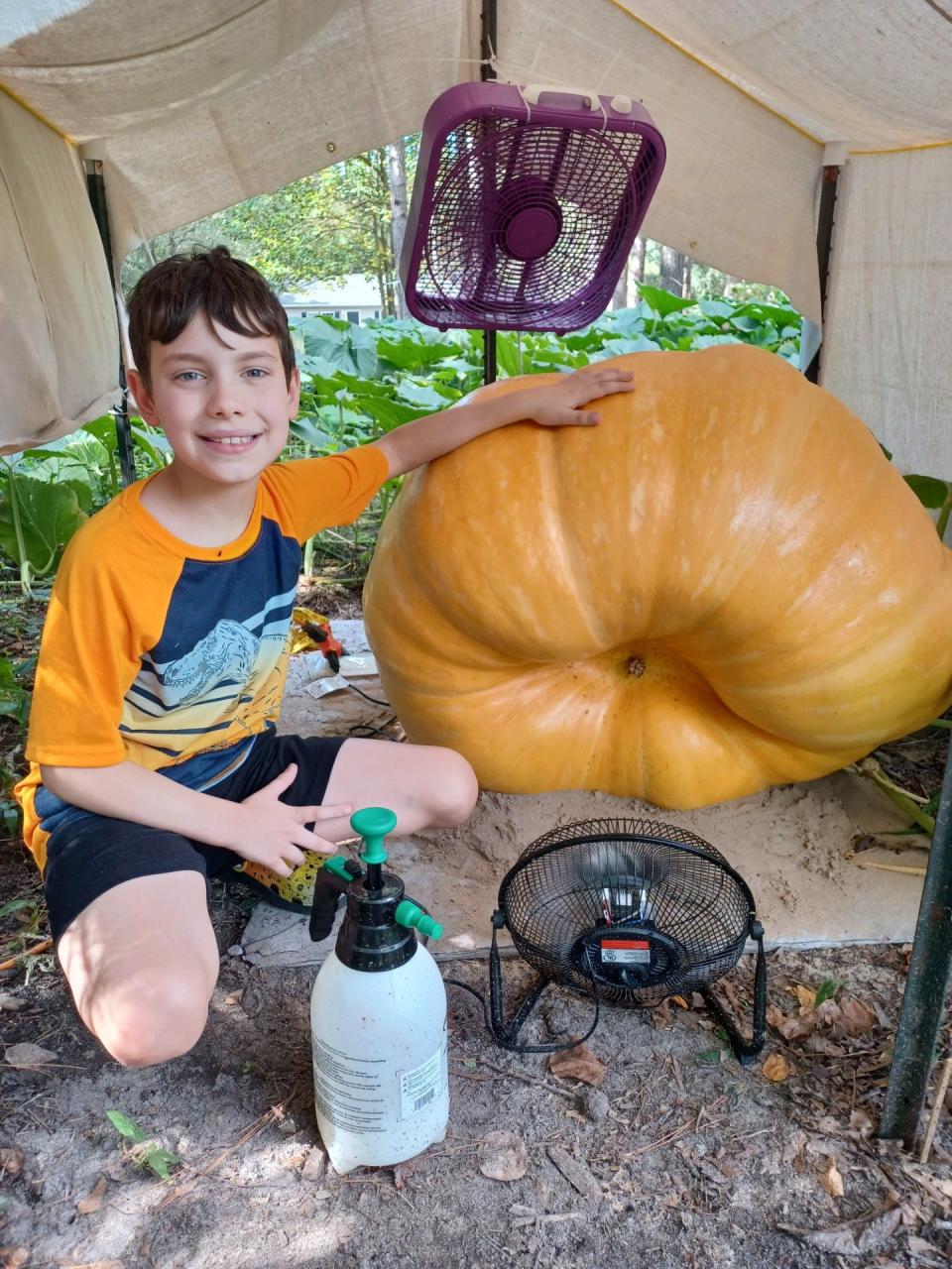 Ten-year-old Christian Covey of Stony Creek poses with his giant pumpkin in Stony Creek, Va. in September 2023.