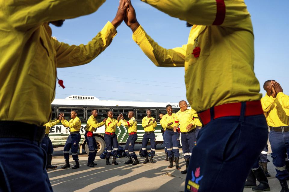 South African firefighters dance during a break in their morning meeting in Fox Creek, Alberta, on Tuesday, July 4, 2023. Several countries, including South Africa, deployed firefighters to Canada to help local efforts to control widespread wildfires. (AP Photo/Noah Berger)