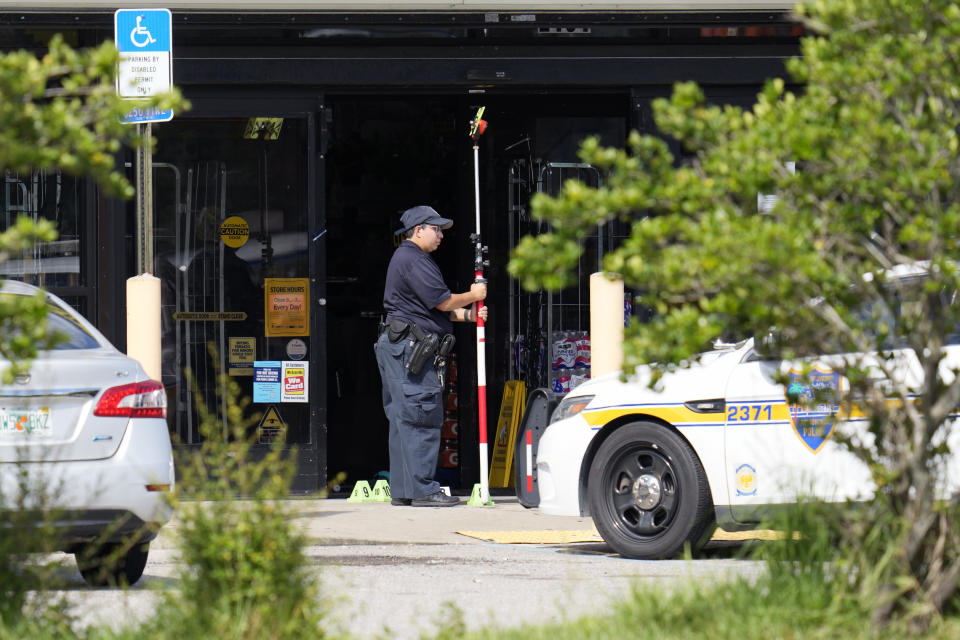 Law enforcement officers take measurements in front of a Dollar General store, Sunday, Aug. 27, 2023, in Jacksonville, Fla., at the scene of a mass shooting a day earlier. (AP Photo/John Raoux)