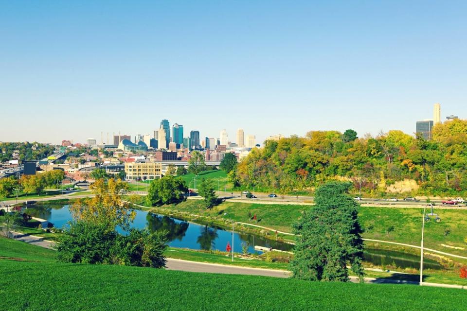 Park with small lake in front of city skyline.