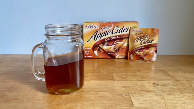 apple cider in glass mug next to package of Instant Alpine