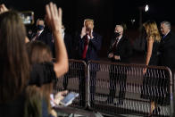 President Donald Trump gestures to supporters before boarding Air Force One at Nashville International Airport after participating in the presidential debate, Thursday, Oct. 22, 2020, in Nashville, Tenn., as first lady Melania Trump watches. (AP Photo/Evan Vucci)