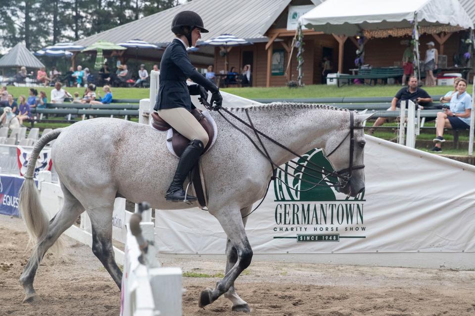 Scottie Arnold smiles as she leaves the ring with her horse Quinito after competing in the hunter/jumper versatility challenge during the first day of the Germantown Charity Horse Show on Tuesday, June 7, 2022, at the show grounds, 7745 Old Poplar Pike. The show continues through June 11. 