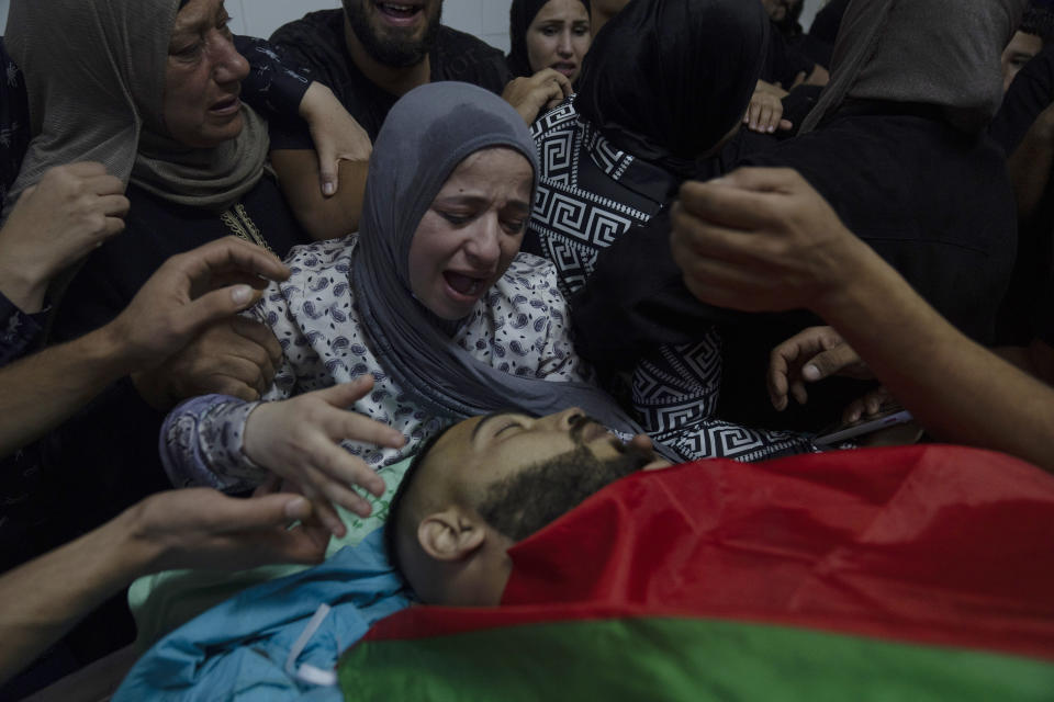Alaa Jadelhaq, wife of Mohanad Jadelhaq, 29 takes the last look at his body during his funeral in the West Bank city of Ramallah, Thursday, Nov. 9, 2023. Jadelhaq was killed during an Israeli army raid in the occupied West Bank refugee camp of Amari, Palestinian ministry of health said. (AP Photo/Nasser Nasser)