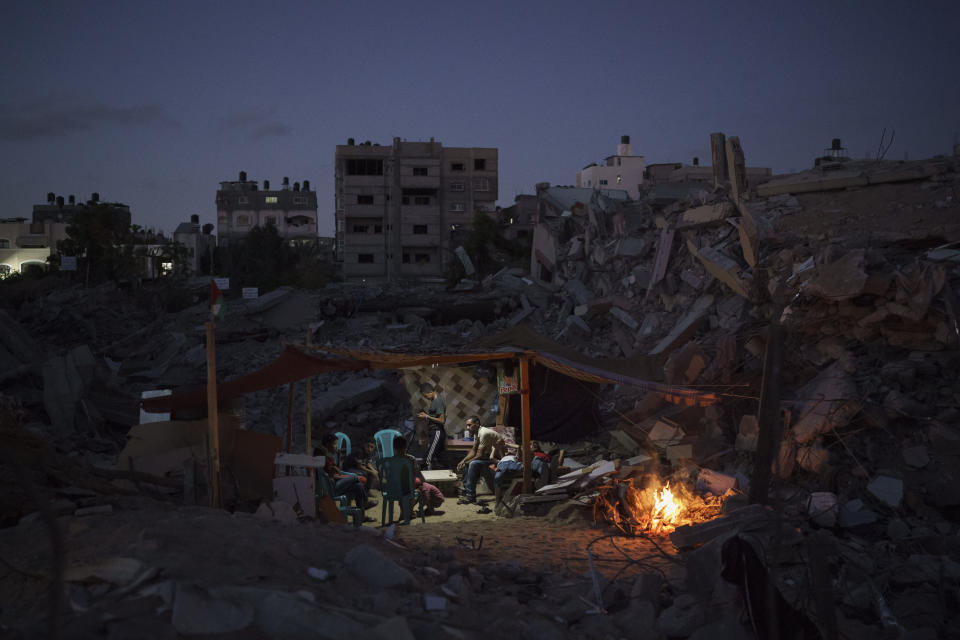 A family sits inside a makeshift tent built among the rubble of their home, destroyed by an airstrike in Beit Lahiya, northern Gaza Strip,, Monday, June 14, 2021. (AP Photo/Felipe Dana)