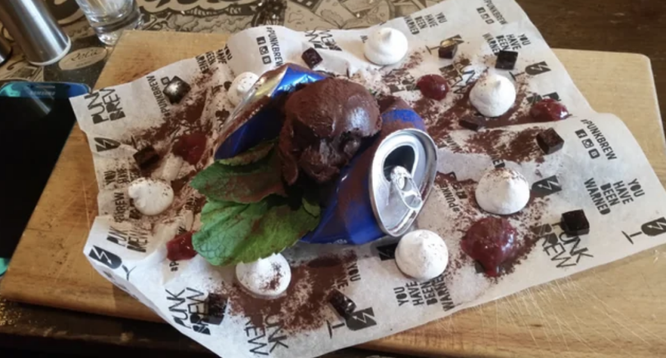 A chocolate mousse–type lump on top of what looks like a crushed soda can and a piece of paper saying "You have been warned"