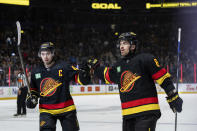 Vancouver Canucks' Quinn Hughes (43) celebrates with Conor Garland (8) after Garland's goal against the Arizona Coyotes during the third period of an NHL hockey game Wednesday, April 10, 2024, in Vancouver, British Columbia. (Ethan Cairns/The Canadian Press via AP)
