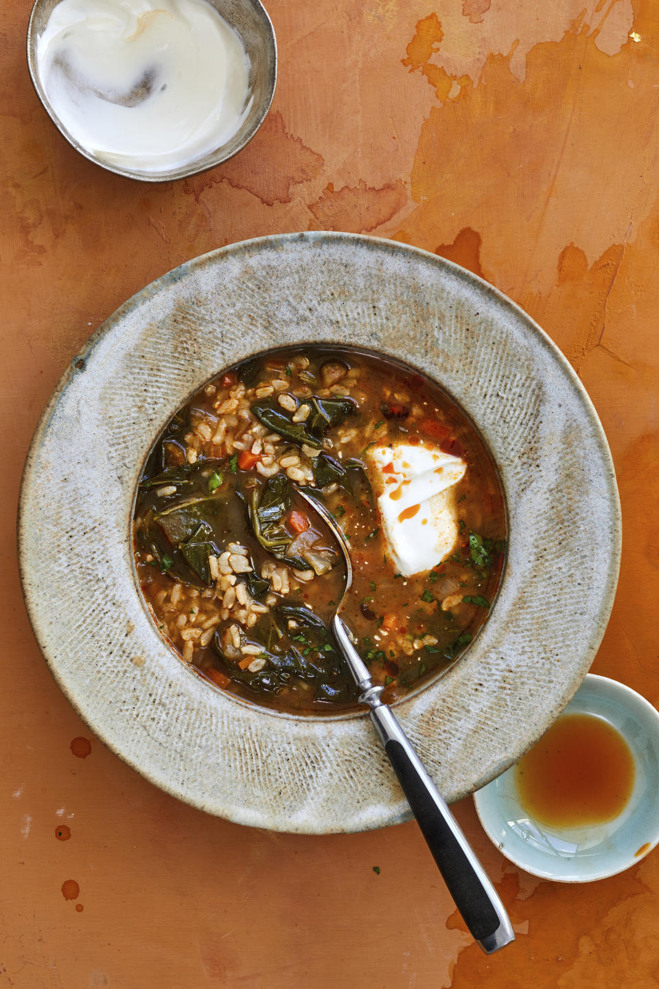 This image provided by Beatriz da Costa shows collard greens and rice soup, a recipe from "The Simple Art of Rice: Recipes from Around the World for the Heart of Your Table," a book by chef JJ Johnson and Danica Novgorodoff. (Beatriz da Costa via AP)