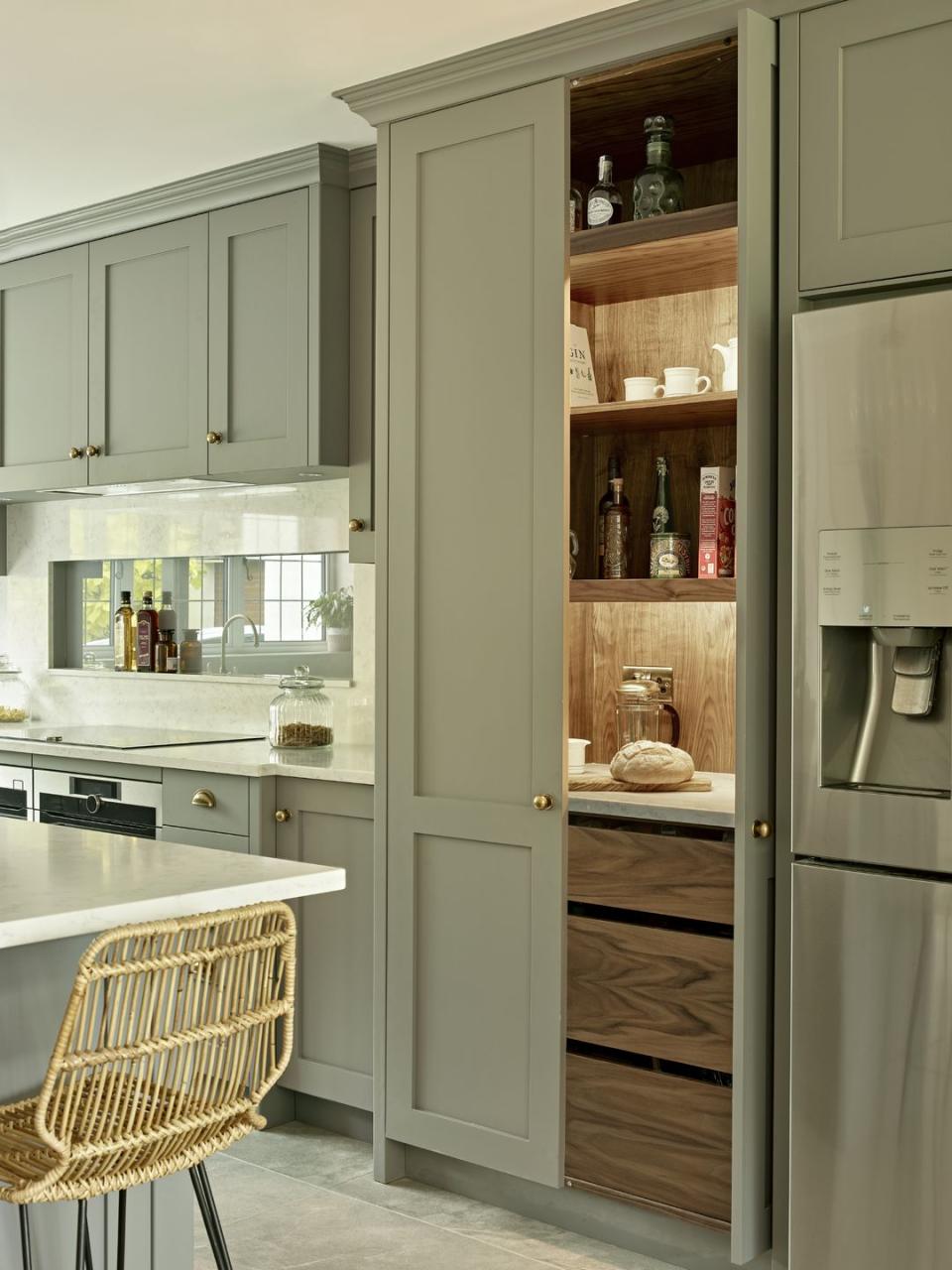 <p>In a stylish sage green hue, this kitchen looks like something you might scroll past on Instagram. The practical kitchen larder unit — with pull-out drawers and wooden shelves – is ideal for displaying jars, tins and home accessories. </p><p>• See more from <a href="https://brayerdesign.co.uk/" rel="nofollow noopener" target="_blank" data-ylk="slk:Brayer Design;elm:context_link;itc:0;sec:content-canvas" class="link ">Brayer Design</a> </p>