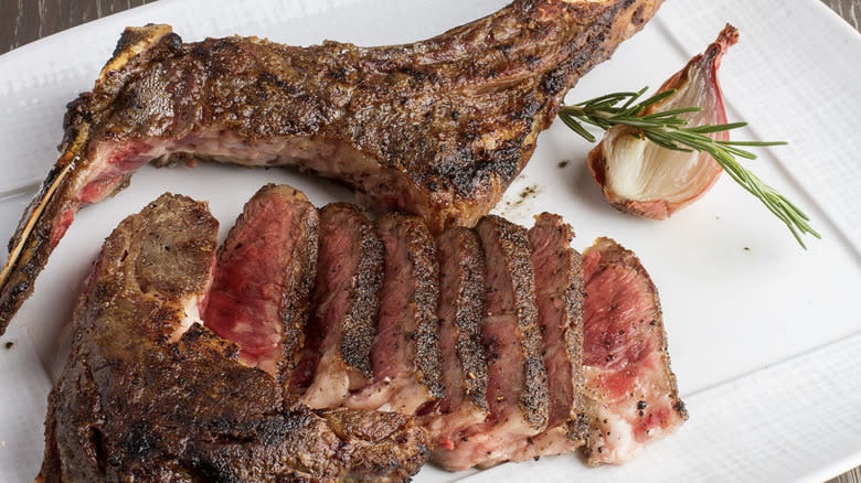 Plate of steak with garlic and rosemary sprig