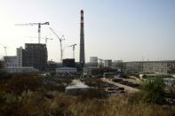 Towering chimneys emerge from the sand dunes of the Thar desert as Pakistani and Chinese workers toil away on a 660-megawatt power plant