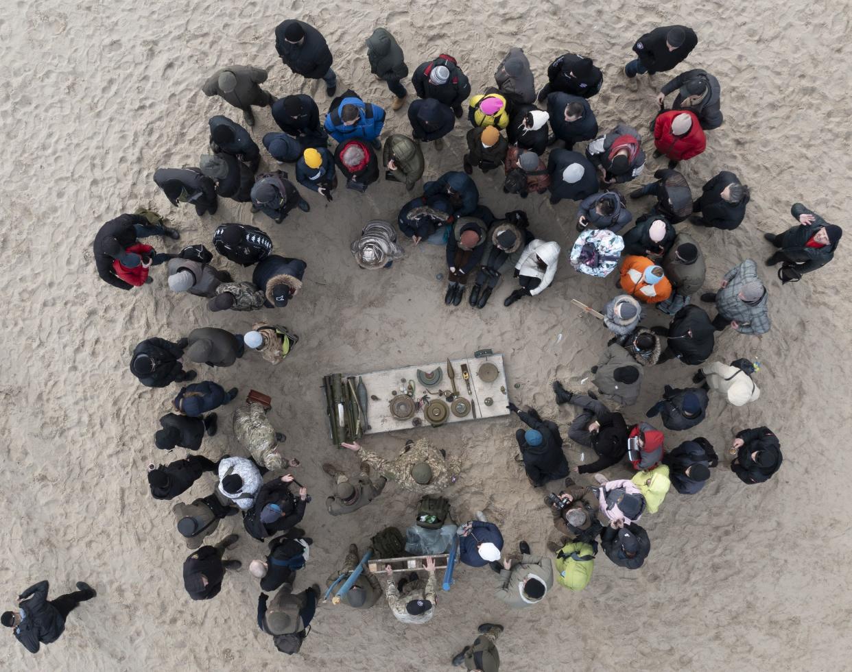 Civilians study weapons during a training session by Ukrainian right-wing group Right Sector in a city park in Kyiv, Ukraine, Sunday, Feb. 20, 2022.