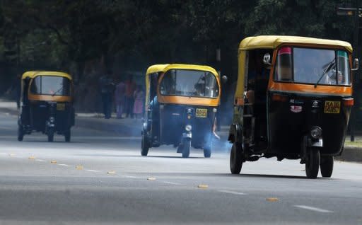 A trio of auto-rickshaws emit exhaust fumes on a busy road in Bangalore in 2009. Carbon dioxide emitted by energy use hit a record high last year, dimming prospects for limiting global warming to two degrees Celsius, the International Energy Agency (IEA) said Monday