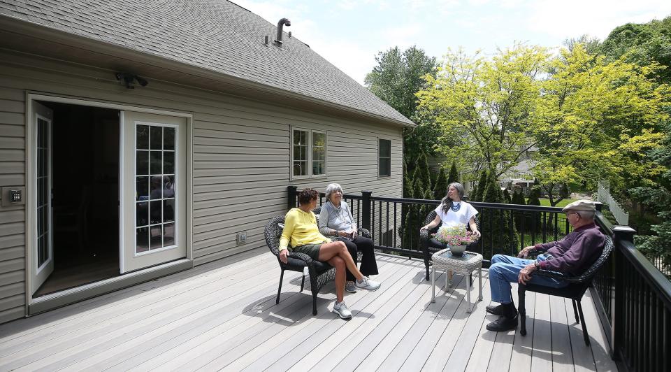 Camella Living co-founder April Daniska sits down on the patio with a couple of residents at Camella Living in Copley on Wednesday.