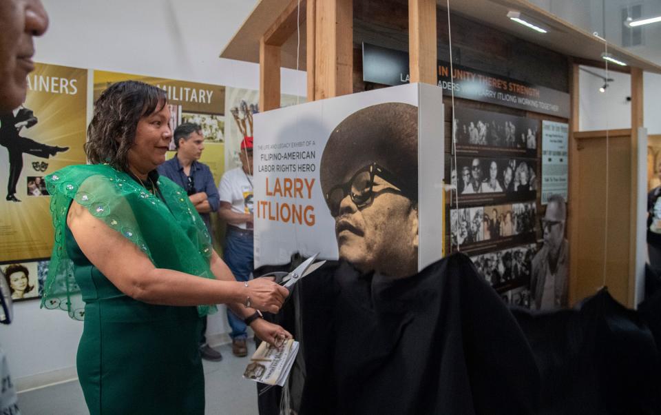 Patty Itliong Serda unveils an exhibit about her father, farm labor activist Larry Itliong, during a ceremony at the Filipino American National Historic Society museum in downtown Stockton on Saturday, Oct. 21, 2023.