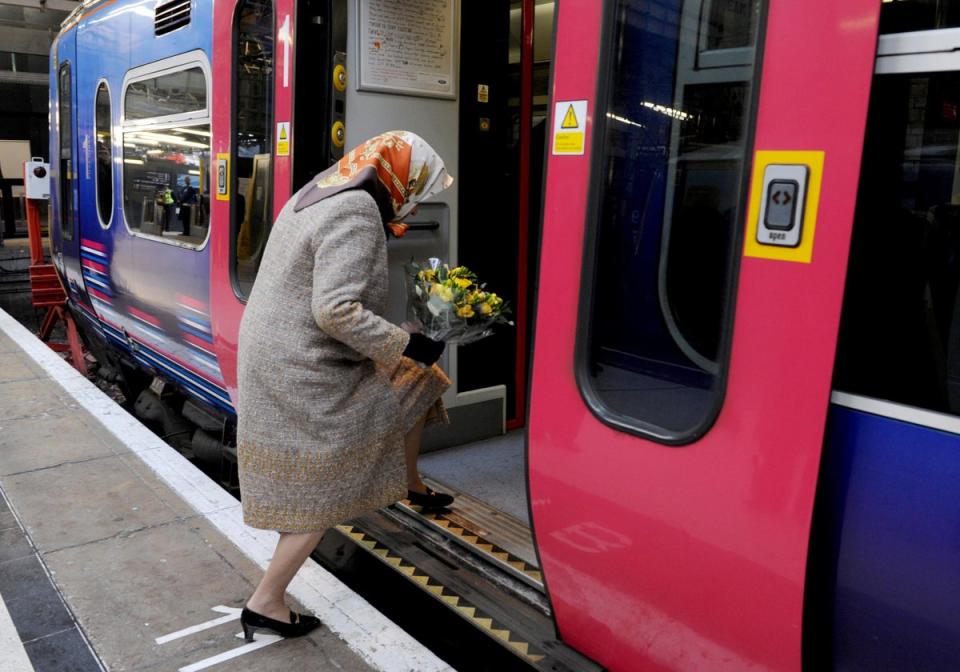 Queen Elizabeth boards a scheduled train at Kings Cross station in London, 2009 (Getty)