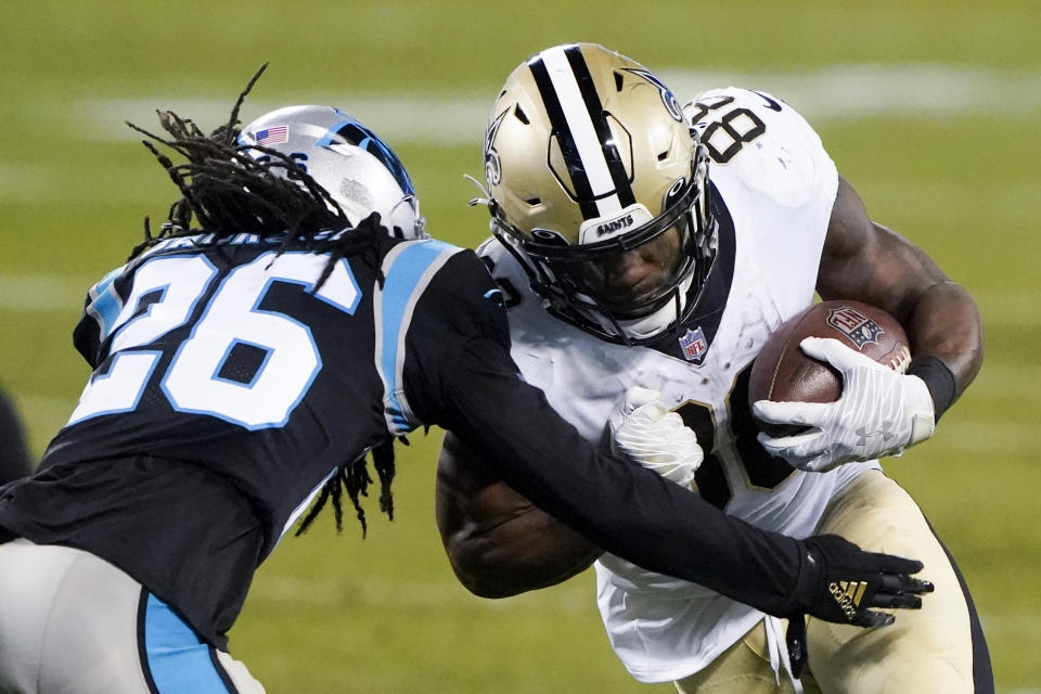 New Orleans Saints running back Ty Montgomery, right, is tackled by Carolina Panthers cornerback Donte Jackson during the second half of an NFL football game Sunday, Jan. 3, 2021, in Charlotte, N.C. (AP Photo/Brian Blanco)