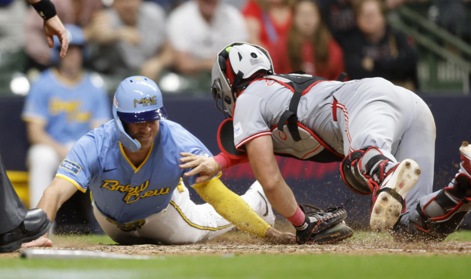 Cincinnati Reds' Tyler Stephenson, right, tags out Milwaukee Brewers' Jake Bauers during the ninth inning of a baseball game Friday, June 14, 2024, in Milwaukee. (AP Photo/Jeffrey Phelps)