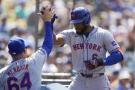 New York Mets' Starling Marte celebrates with manager Carlos Mendoza (64) after hitting a home run during the sixth inning of a baseball game against the Los Angeles Dodgers in Los Angeles, Saturday, April 20, 2024. Zack Short and Brandon Nimmo also scored. (AP Photo/Ashley Landis)