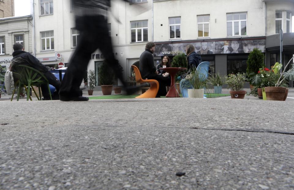 A man walks past people participating in a PARK(ing) Day event in Riga, September 20, 2013. (REUTERS/Ints Kalnins)