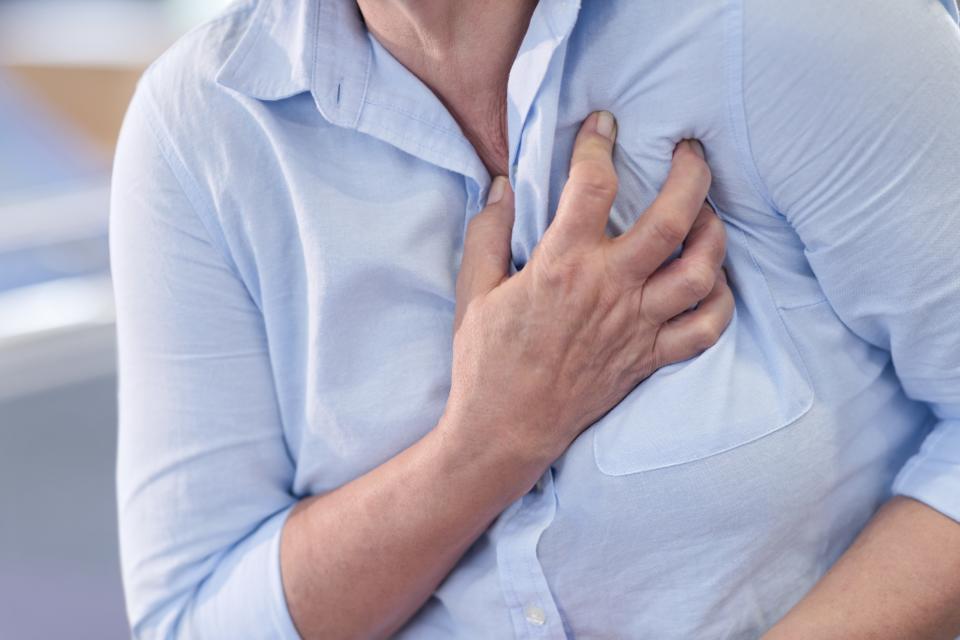 person clutching their chest having a heart attack