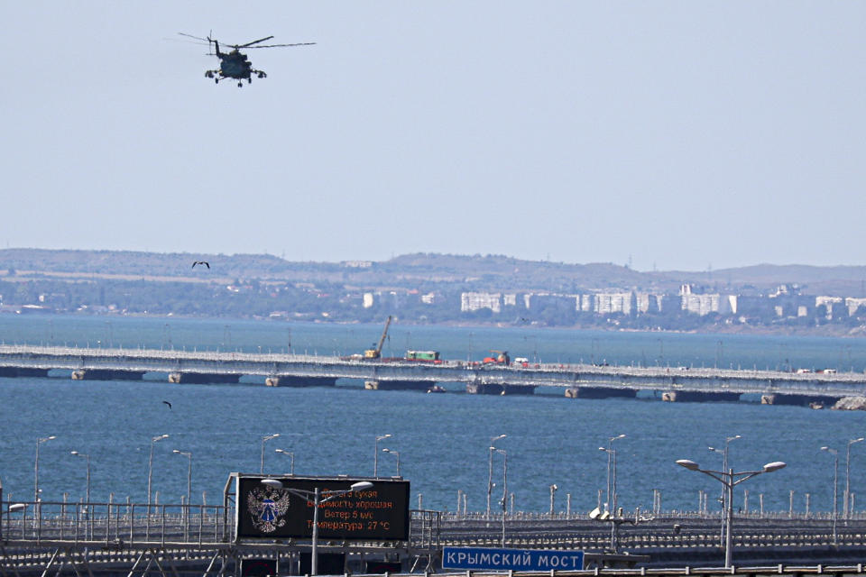Un helicóptero militar ruso vuela sobre partes dañadas del puente que conecta a Rusia con la península de Crimea sobre el Estrecho de Kerch, el lunes 17 de julio de 2023, no lejos de Kerch, Crimea. (AP Foto)