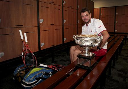 Stanislas Wawrinka of Switzerland sits with the Norman Brookes Challenge Cup in the locker room after defeating Rafael Nadal of Spain in their men's singles final match at the Australian Open 2014 tennis tournament in Melbourne January 26, 2014. REUTERS/Fiona Hamilton/Tennis Australia/Handout