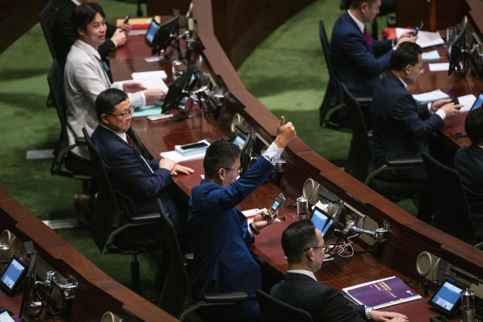 A lawmakers gestures during the voting after the third reading of the Basic Law Article 23 legislation at the Legislative Council in Hong Kong, Tuesday, March 19, 2024. (AP Photo/Louise Delmotte)