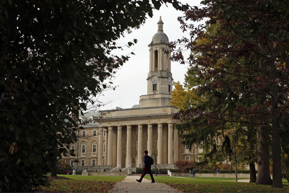 FILE- In this Nov. 9, 2017, file photo people walk by Old Main on the Penn State University main campus in State College, Pa. The Free Application for Federal Student Aid, or FAFSA, becomes available Monday, Oct. 1, 2018. It’s widely considered the most important document in securing money for higher education as current and prospective students must fill it out annually to get federal student aid including loans, grants, work-study and certain scholarships. (AP Photo/Gene J. Puskar, File)