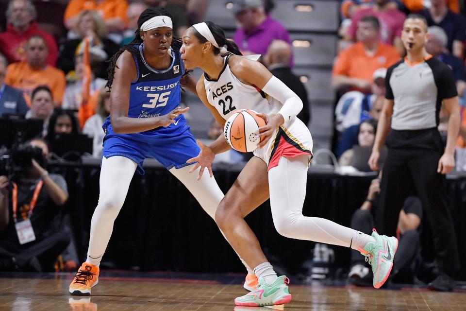 Las Vegas Aces' A'ja Wilson dribbles as Connecticut Sun's Jonquel Jones defends during the first half in Game 3 of basketball's WNBA Finals on Thursday, Sept. 15, 2022, in Uncasville, Conn. (AP Photo/Jessica Hill)